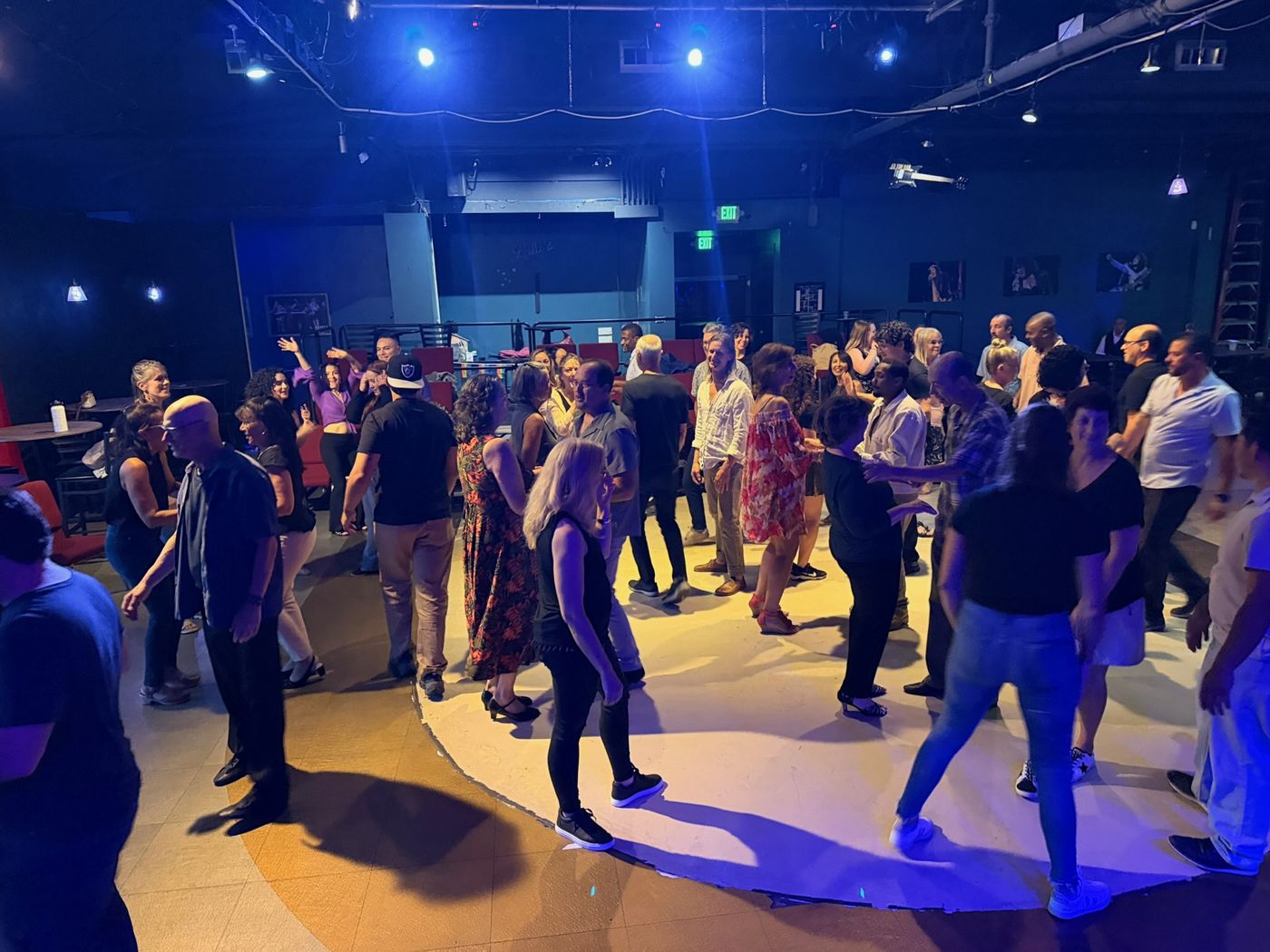 A busy Salsa social with dancers moving across the floor